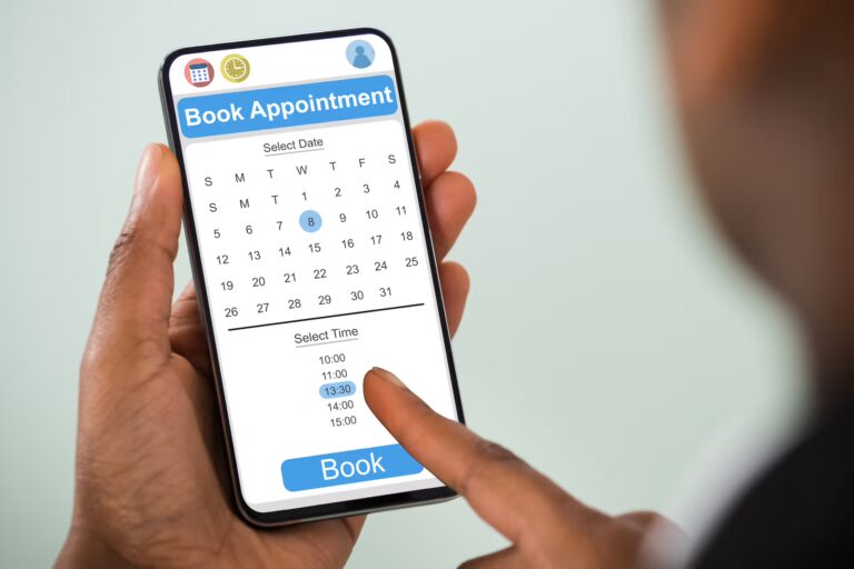 Close-up of a hand holding a smartphone displaying a calendar app for booking an appointment.