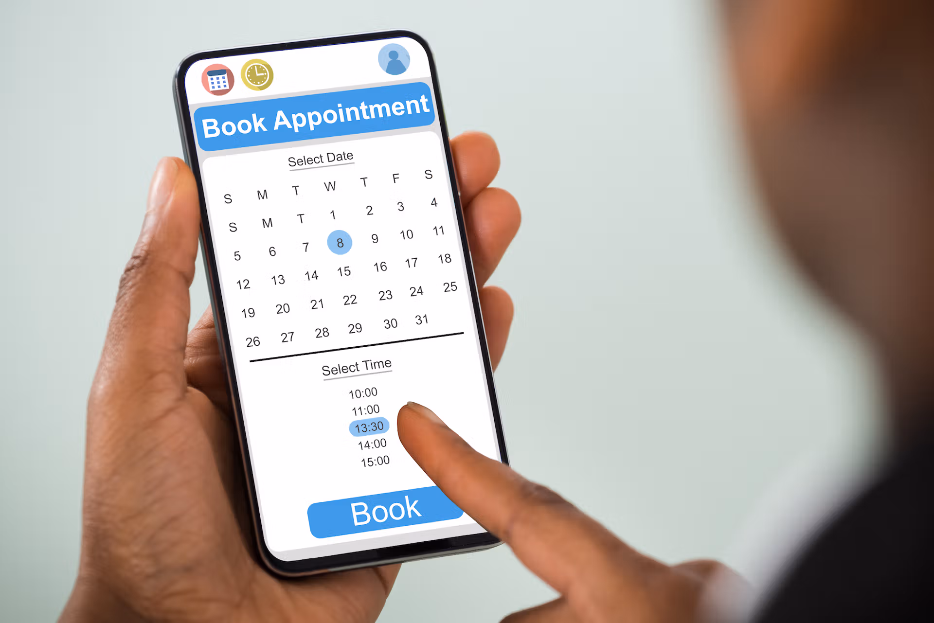 Close-up of a hand holding a smartphone displaying a calendar app for booking an appointment.