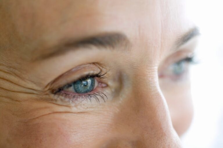 Close-up portrait of a woman, featuring prominent wrinkles that convey wisdom and maturity.