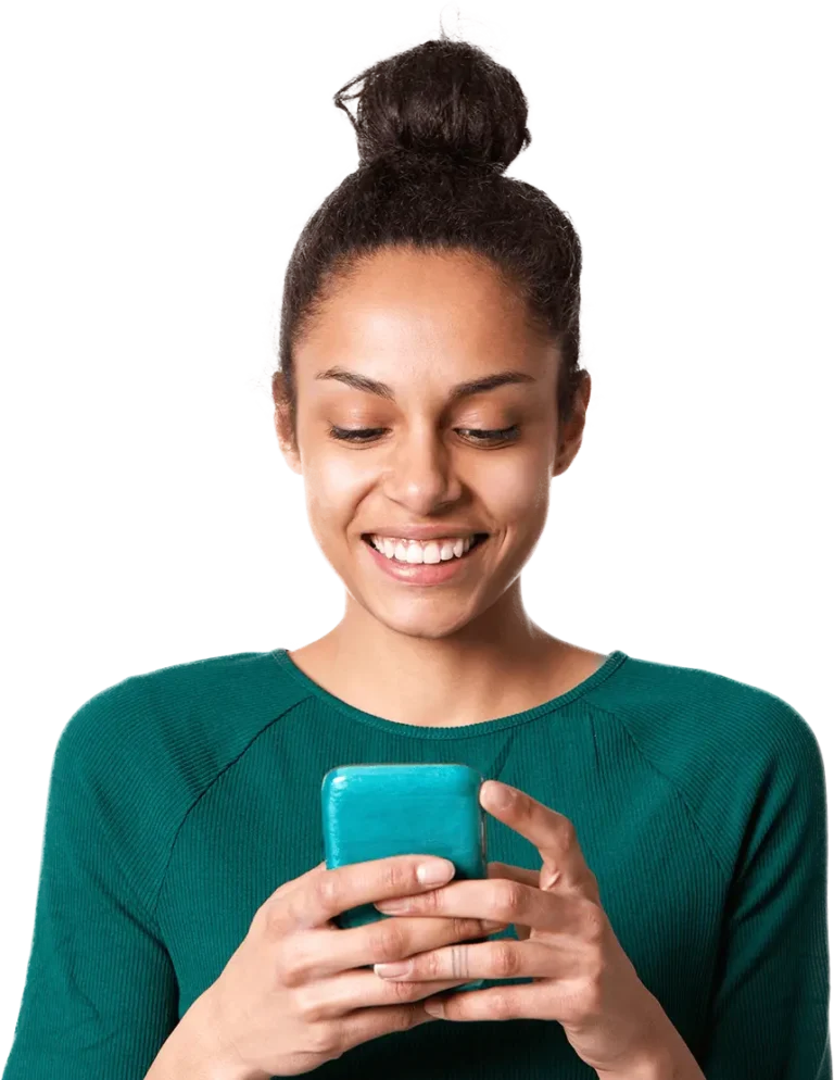 A woman smiles brightly while engaging with her cell phone, showcasing a moment of joy and connection.