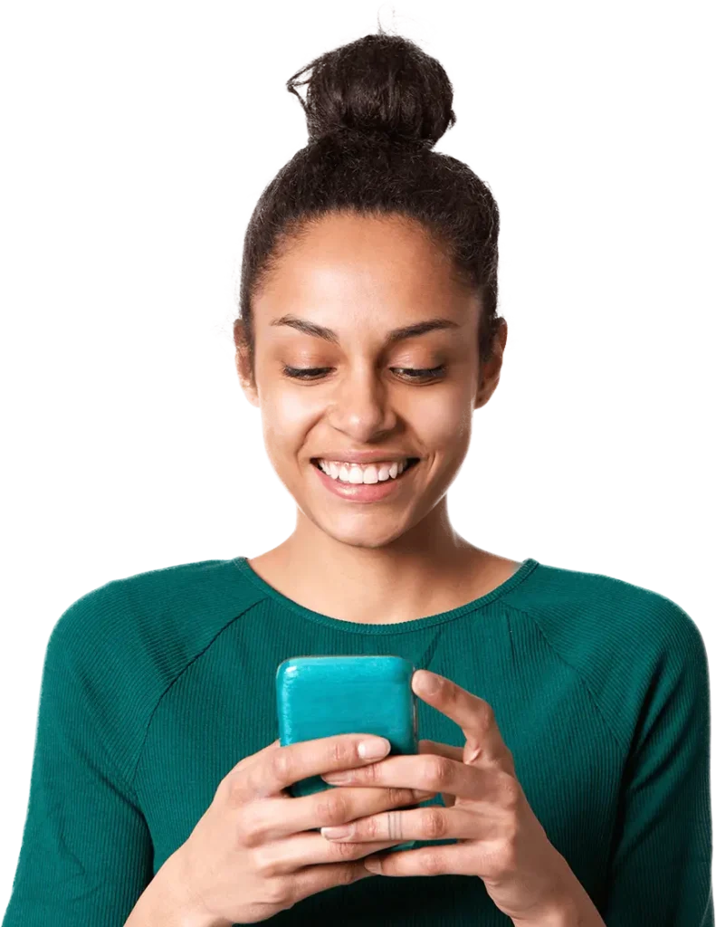 A woman smiles brightly while engaging with her cell phone, showcasing a moment of joy and connection.